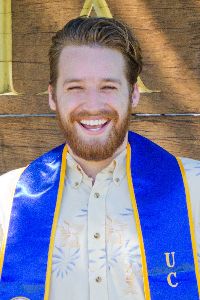 photo of stephan preston laughing in collared shirt with graduate sash