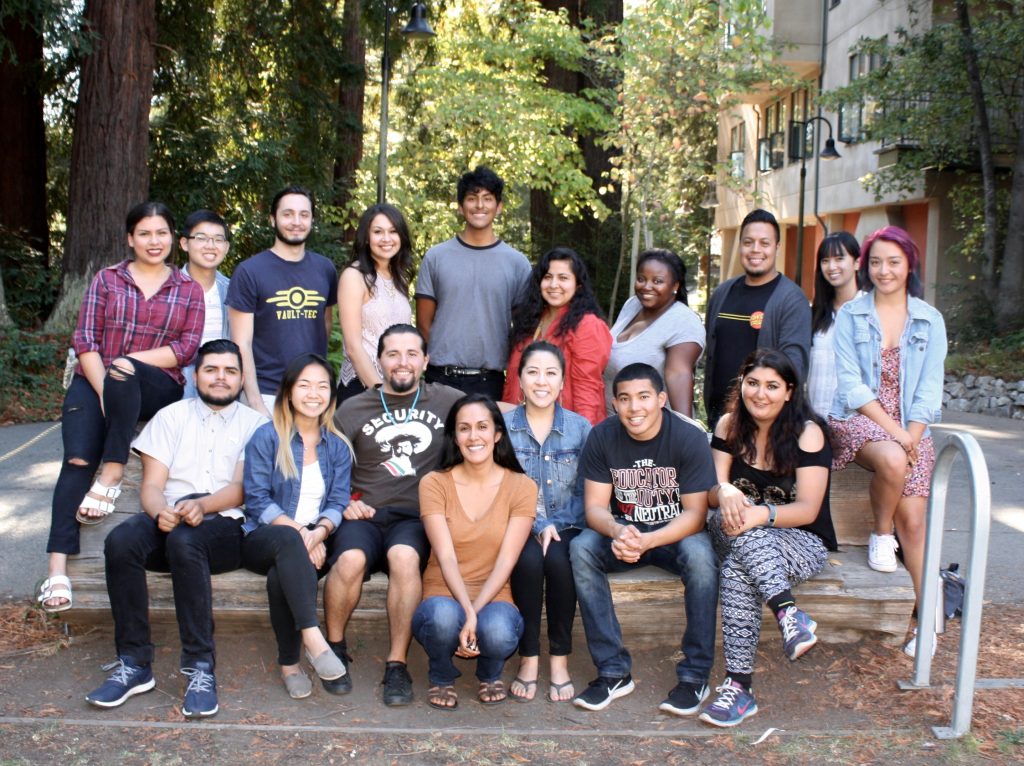 research team sitting on a bench in front of social sciences building