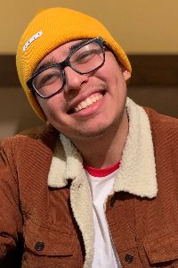 photo of alejandro mora smiling in yellow beanie and brown fur jacket