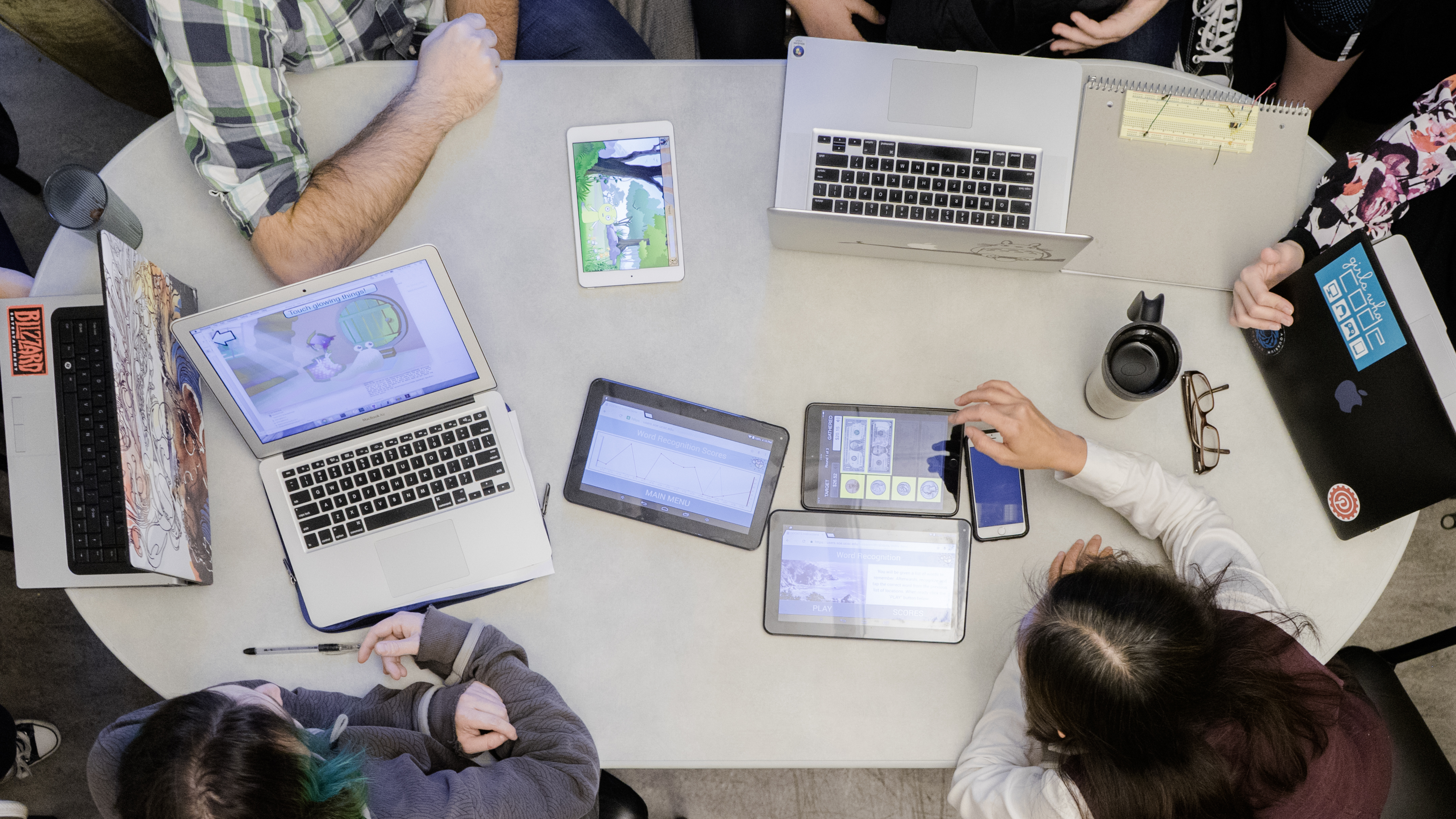 photo from above of a table with students working together on their laptops