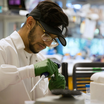 student scientist in lab coat checking lab work